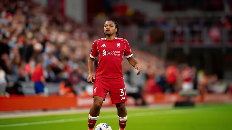 A young footballer in a Liverpool kit, representing Rio Ngumoha, with a football at his feet on a green pitch. — latest news and analysis.
