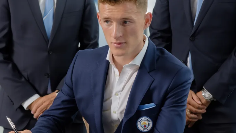 Elliot Anderson signing a contract with Manchester City officials