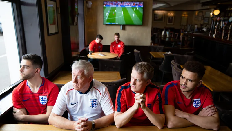 England fans watching a football match at a pub in Brantingham, East Yorkshire, with expressions of anticipation and disappointment.