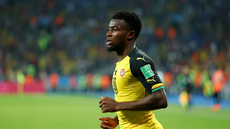 Thomas Partey in Ghana national team jersey, looking focused during a match, with stadium background. — latest news and analysis.