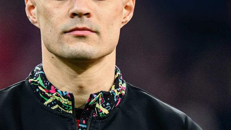 Granit Xhaka in a football kit, looking towards the camera with a determined expression.