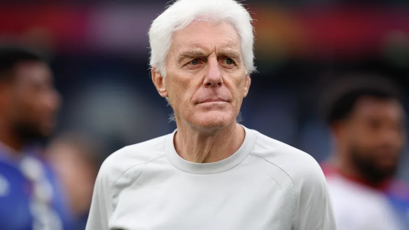 South Africa coach Hugo Broos looks on during a World Cup match, with players in the background. — latest news and analysis.
