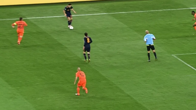 Andrés Iniesta celebrates after scoring the winning goal in the 2010 FIFA World Cup final, with teammates surrounding him.