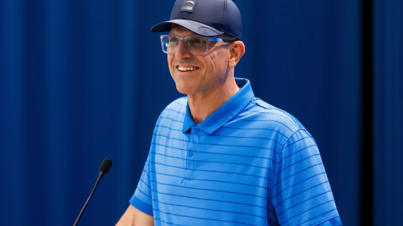 Jim Harbaugh, head coach of the Los Angeles Chargers, speaks at a press conference with a microphone in hand. — latest news and analysis.