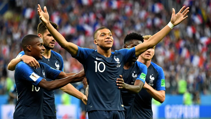 Mbappe equals France scoring record, eyes more milestones Kylian Mbappe celebrates scoring for France in a World Cup match, with teammates around him and the crowd in the background.