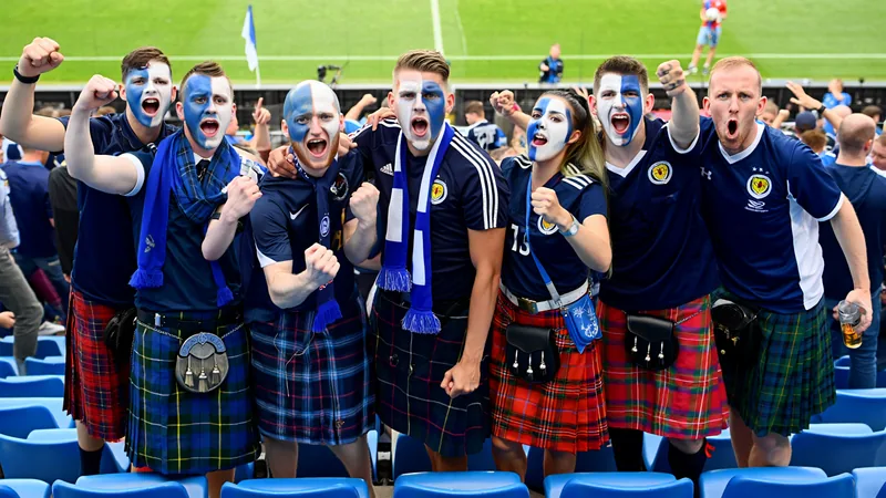 Scotland fans in kilts and face paint cheering at a World Cup match