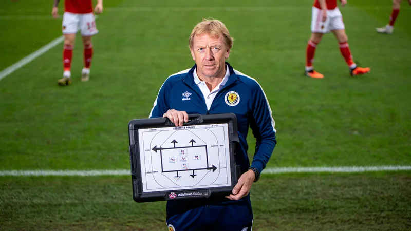 Scottish set-piece coach Austin MacPhee key to Portugal's World Cup Austin MacPhee, a blonde-haired Scottish coach, stands on the touchline during a football match, holding a tactics board.