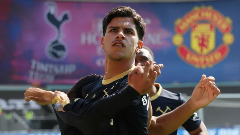 Mateus Fernandes in West Ham United kit, celebrating a goal, with Tottenham Hotspur and Manchester United logos in background.