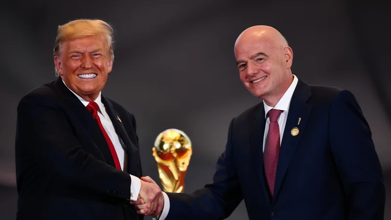 FIFA President Gianni Infantino and former U.S. President Donald Trump shaking hands at a meeting, with a World Cup trophy in the background.