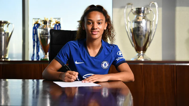 Aggie Beever-Jones signs new Chelsea contract until 2030 Aggie Beever-Jones in Chelsea kit signing contract, with trophy backdrop