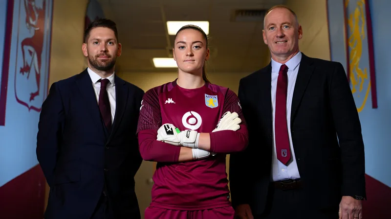 Aston Villa sign goalkeeper Emily Ramsey on free transfer Emily Ramsey in Aston Villa goalkeeper kit posing for a photo with club officials