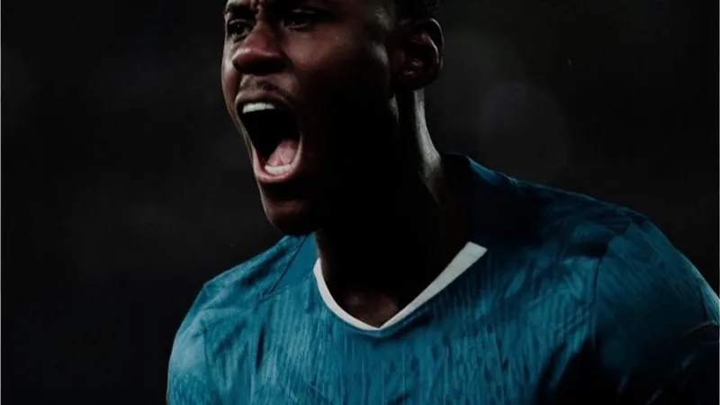 Trevoh Chalobah in Chelsea kit during a match, with Como and Chelsea logos in background.