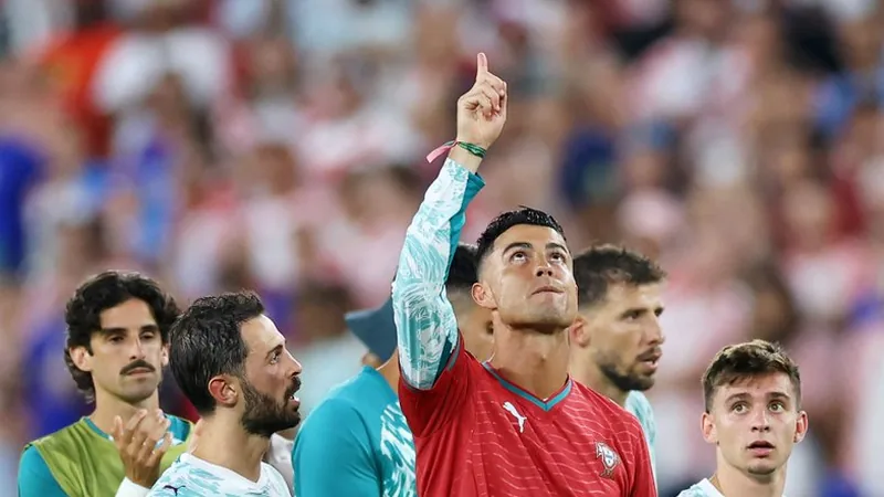 Cristiano Ronaldo wearing Diogo Jota's shirt, pointing to the sky with tears in his eyes.