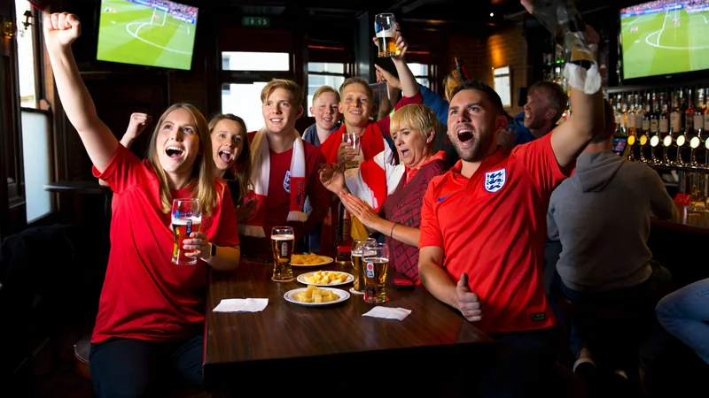 England fans gather early for World Cup win over Mexico England football fans cheering in a pub during the early hours of the morning, watching a World Cup match on large screens.