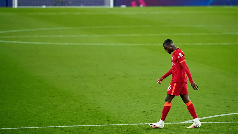 Jarell Quansah walks off the pitch after receiving a red card during a football match.