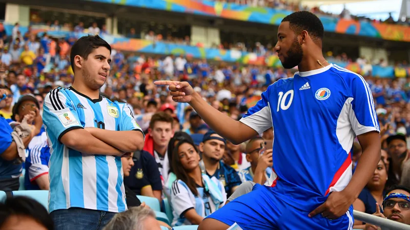 IShowSpeed wearing a Cape Verde kit confronts an Argentina fan in the stands at Hard Rock Stadium during the World Cup match.