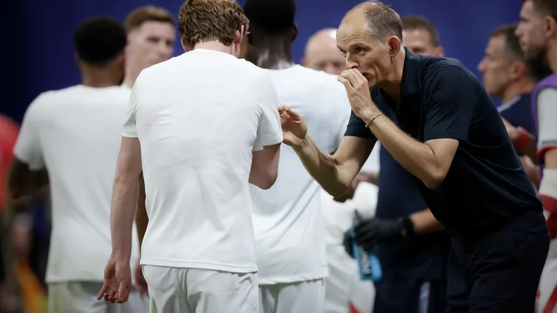 England football team in dejection after World Cup defeat, with Thomas Tuchel looking on from the sidelines. — latest news and analysis.