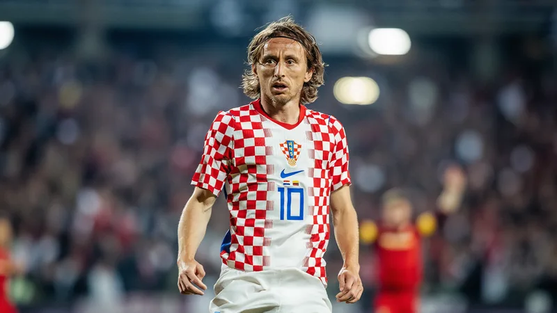 Luka Modric in Croatia jersey, mid-stride on a soccer field, focused expression, stadium background — latest news and analysis.