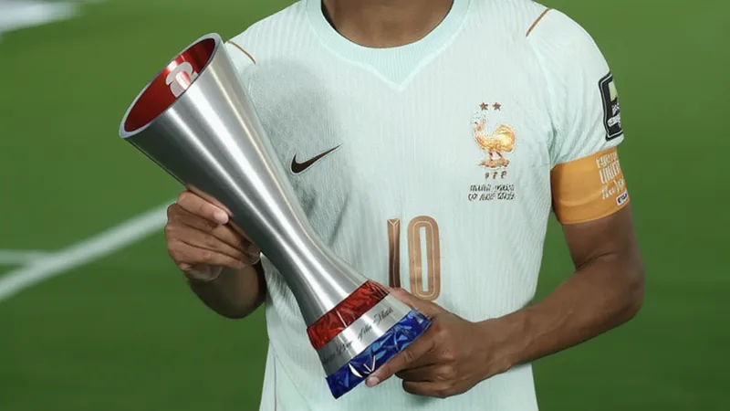 Kylian Mbappé holding a FIFA Man of the Match trophy on the pitch