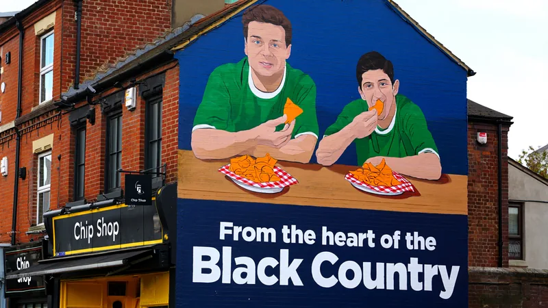 Mural of Bellingham and Rogers eating orange chips appears in A mural on the side of a chip shop showing two footballers eating orange chips, with the words 'From the heart of the Black Country'.