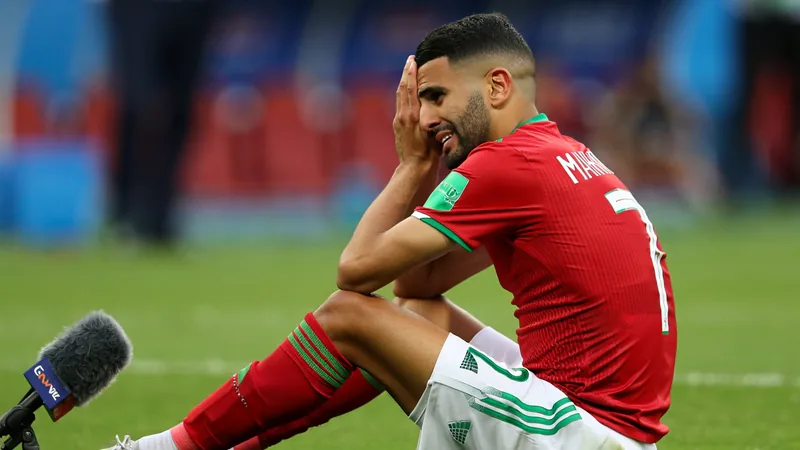 Riyad Mahrez in Algeria jersey, looking emotional after World Cup defeat to Switzerland, announcing retirement. — latest news and analysis.