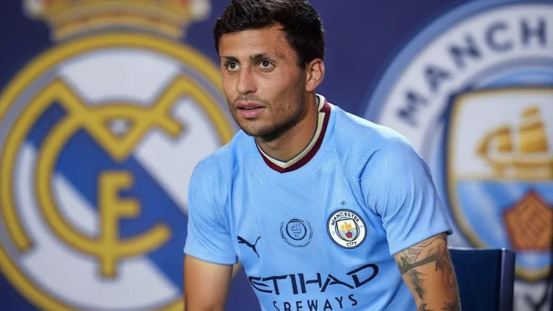 Rodri in Manchester City kit during a match, with Real Madrid and Man City logos in background. — latest news and analysis.