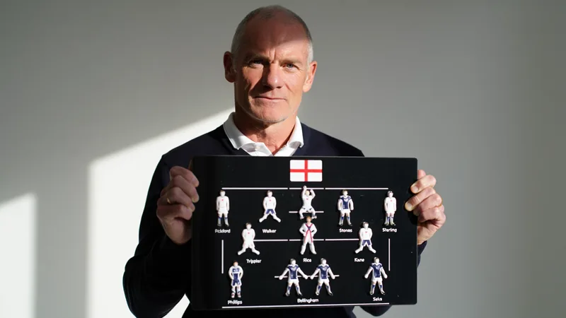 Alan Shearer holding a tactics board with England lineup