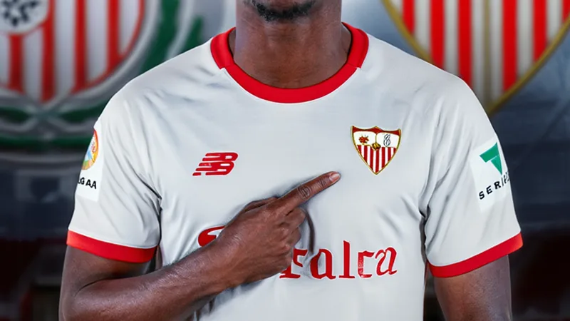 Akor Adams in Sevilla kit celebrating a goal, with Venezia and Sevilla logos in background