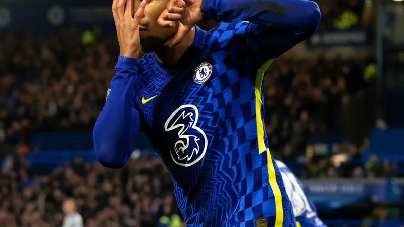 João Pedro Agrees New Chelsea Contract Until 2033 João Pedro in Chelsea kit, celebrating a goal, with Stamford Bridge in background.