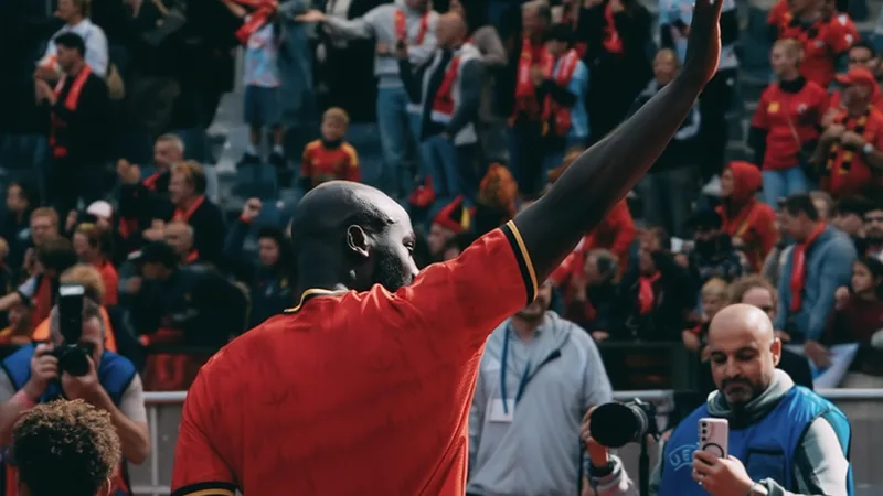 Lukaku Agrees to Fenerbahçe Move, Awaiting Club Talks Romelu Lukaku in a football stadium, wearing a jersey, with a determined expression.