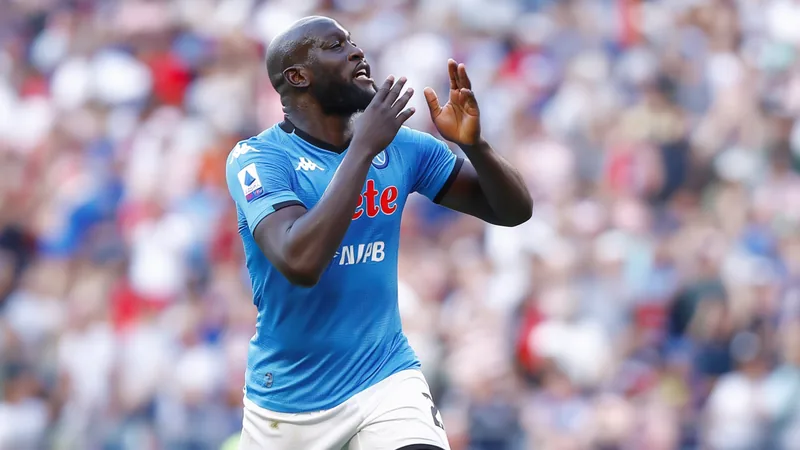 Romelu Lukaku in Napoli kit during a match, with fans in the background.