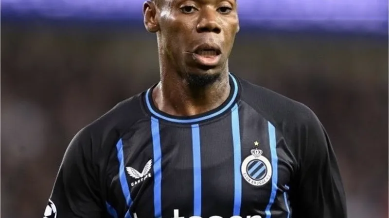 Raphael Onyedika in action during a football match, wearing a Club Brugge jersey.