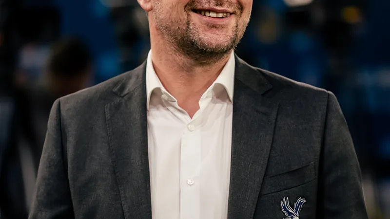 Crystal Palace einigt sich mit Pierre Sage über Cheftrainer-Posten Pierre Sage im Trainingsanzug von RC Lens, der auf dem Spielfeld steht und taktische Anweisungen gibt, im Hintergrund das Stadion von Lens.