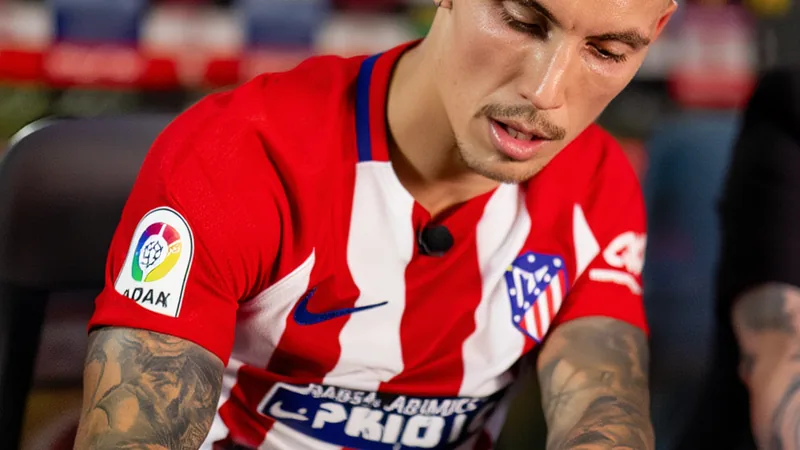 Alejandro Grimaldo im Trikot von Bayer Leverkusen beim Jubel nach einem Tor, im Hintergrund das Stadion von Bayer Leverkusen.