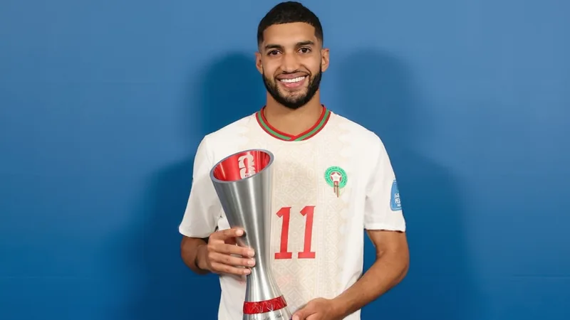 Ismael Saibari zum FIFA-Spieler des Spiels gekürt — Football World Ismael Saibari im marokkanischen Trikot auf dem Spielfeld, wie er den FIFA Man of the Match-Pokal in den Händen hält, mit Stadion im Hintergrund.