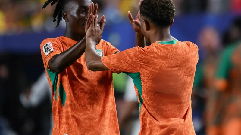 Jungstars Diomande und Diallo weisen Côte d'Ivoire den Weg — Football Jungstar Yan Diomande von RB Leipzig dribbelt im WM-Spiel gegen Ecuador am Ball, im Hintergrund jubelnde ivorische Fans in Philadelphia.