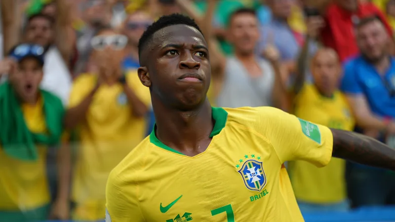 Vinicius Junior: Kann er Brasilien endlich überzeugen? — Football Vinicius Junior im brasilianischen Nationaltrikot mit der Nummer 10, der konzentriert auf dem Spielfeld steht, im Hintergrund jubelnde Fans und die