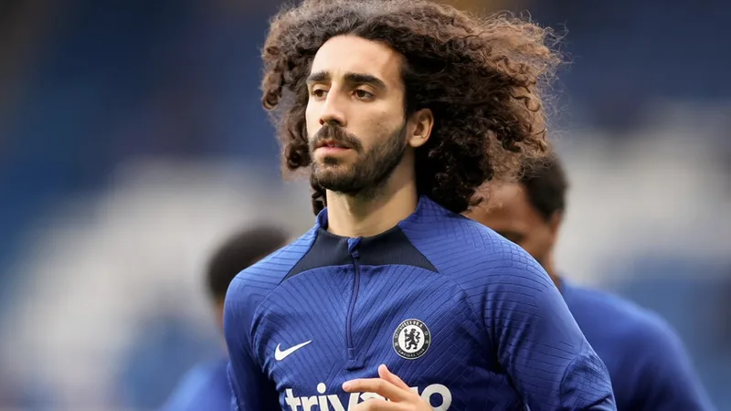 Marc Cucurella im Trikot von Manchester United, der den Ball am Fuß führt, im Hintergrund das Old Trafford Stadion bei Sonnenuntergang