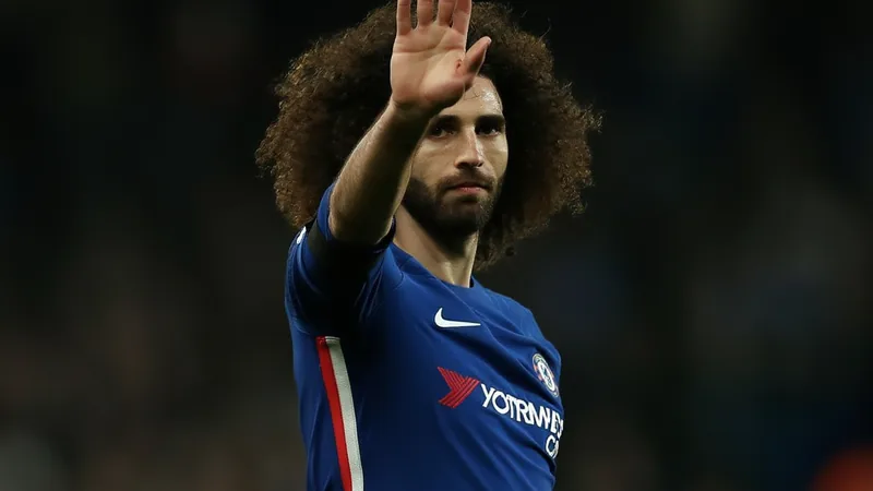Marc Cucurella im Chelsea-Trikot lächelt in die Kamera, im Hintergrund das Stamford Bridge Stadion bei Sonnenuntergang. — latest news and analysis.