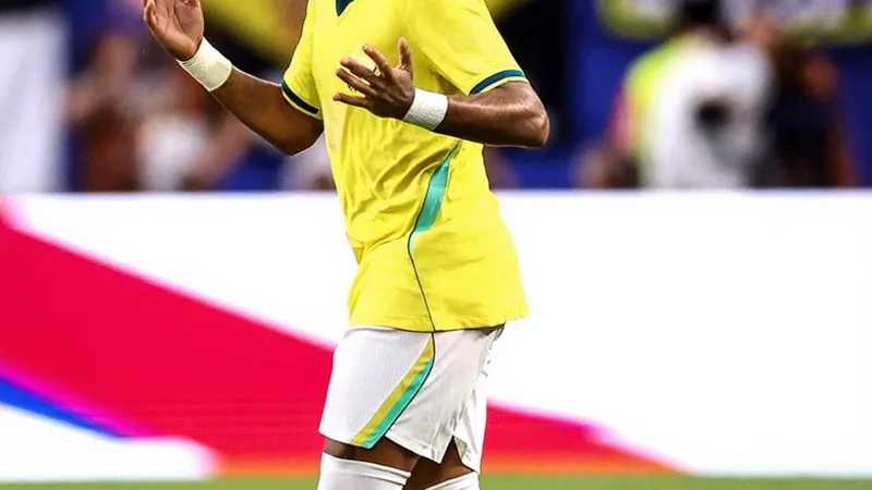 Neymar im brasilianischen Nationaltrikot mit dem Ball am Fuß auf einem Fußballplatz, im Hintergrund die brasilianische Flagge