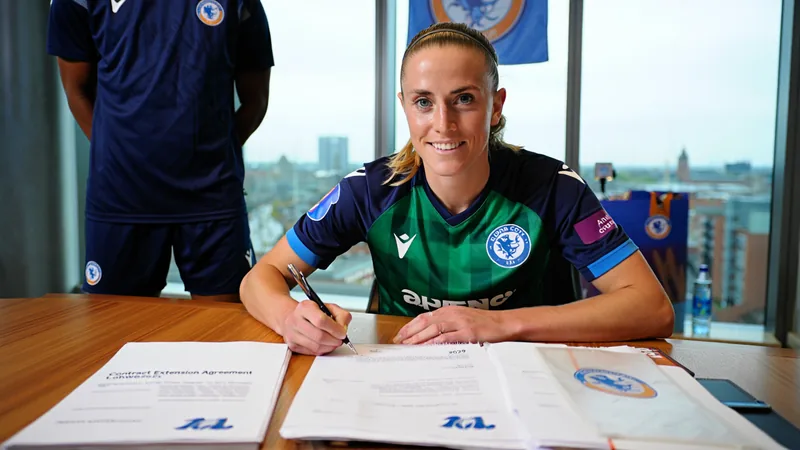 Poppy Pattinson im Trikot der London City Lionesses auf dem Fußballplatz, mit konzentriertem Blick und in Abwehrhaltung.