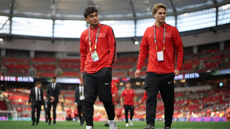 Türkei-Duo Uzun und Yildiz bereit für Bewährungsprobe — Football Can Uzun und Kenan Yildiz im türkischen Trikot auf dem Spielfeld, im Hintergrund die Flagge der Türkei und Stadionatmosphäre.