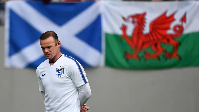 Wayne Rooney: Sympathie für Schottland, aber nicht für Wales Wayne Rooney im englischen Trikot auf dem Fußballfeld, mit ernstem Gesichtsausdruck, im Hintergrund schottische und walisische Flaggen