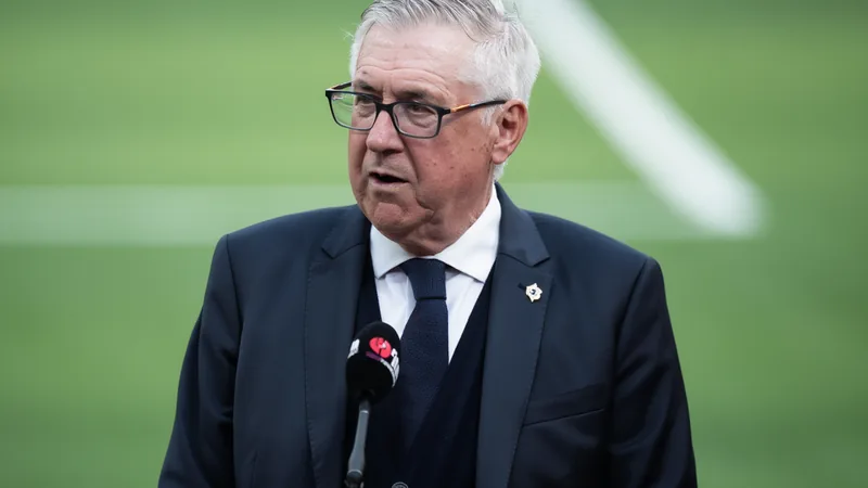 Ancelotti: Vini Jr. nicht unter den Top-5-Elfmeterschützen — Football Carlo Ancelotti in Trainingskleidung auf einem Fußballplatz, im Hintergrund brasilianische Nationalspieler beim Training