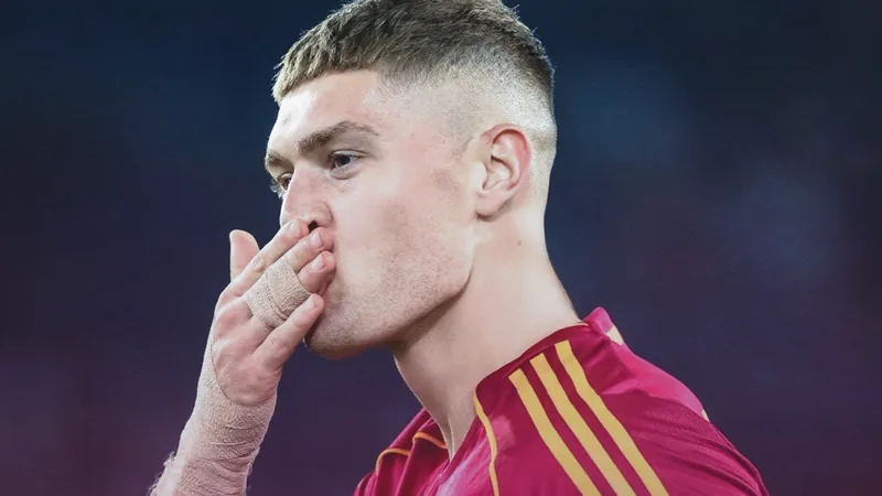 Artem Dovbyk spricht mit Bologna-Trainer Tedesco über Leihe Artem Dovbyk im Trikot der AS Roma beim Training, im Hintergrund das Stadio Olimpico in Rom bei Sonnenuntergang, mit ukrainischer Flagge am