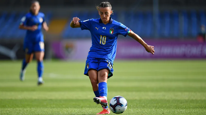 Giulia Dragoni im Trikot der italienischen Nationalmannschaft beim Dribbling gegen eine gegnerische Spielerin auf einem Fußballplatz