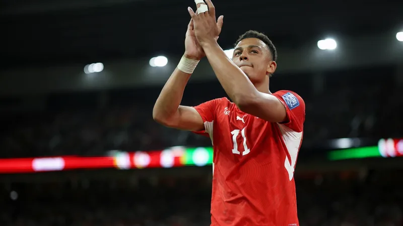 Dan Ndoye vor Achtelfinale Schweiz gegen Kolumbien — Football World Dan Ndoye im Schweizer Nationaltrikot lächelt während eines Interviews vor dem Hintergrund des Lusail-Stadions. — latest news and analysis.