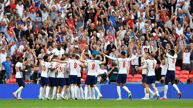Englische Nationalspieler in weißen Trikots jubeln im Atlanta Stadium, im Hintergrund die argentinische Mannschaft in Blau-Weiß.