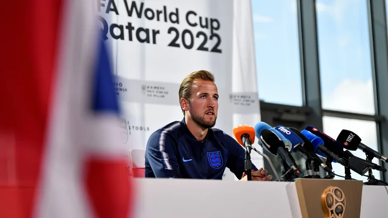 Kane betont Einigkeit: „Leicht, Spaltungen zu erzeugen“ — Football Harry Kane im englischen Trikot spricht auf einer Pressekonferenz mit Mikrofonen vor sich, im Hintergrund das englische Teamlogo.