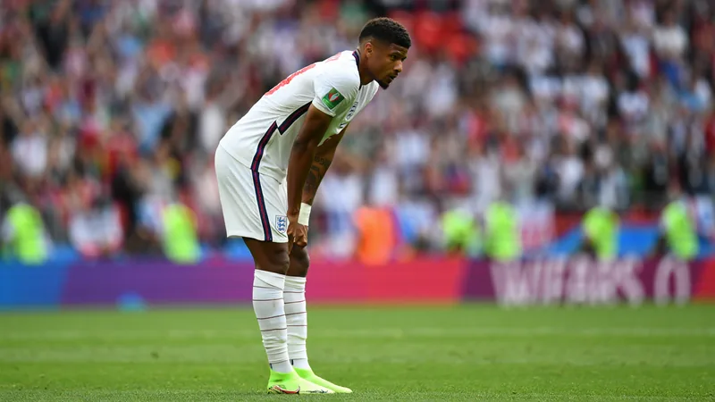 Quansah nach Roter Karte für zwei Spiele gesperrt — Football World Jarell Quansah von Bayer Leverkusen in England-Trikot, der nach einem Foul den Platz verlässt, während der Schiedsrichter die Rote Karte zeigt.